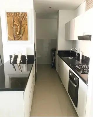 a kitchen with white cabinets and black counter tops at Apt 3 Bedrooms SeaView AC Buenavista in Puerto Colombia