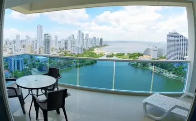a balcony with a table and chairs and a large window at Big in Cartagena de Indias