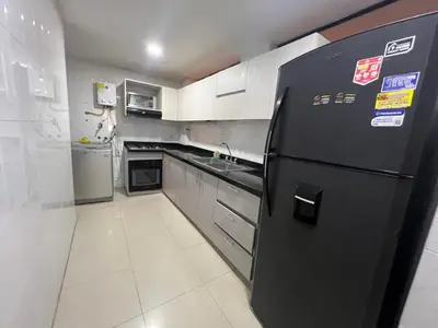 a kitchen with a black refrigerator and a sink at Riomar in Barranquilla