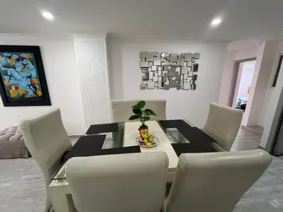 a dining room with a glass table and chairs at Riomar in Barranquilla