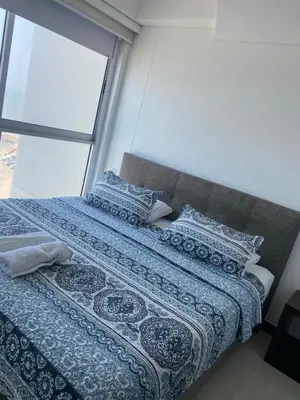 a bed with a blue comforter and pillows on it at Eliptic Cartagena-Oceano in Cartagena de Indias