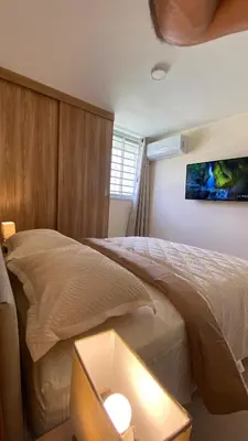 a bedroom with a bed and a tv on the wall at Minimalist and cozy apartment in Barranquilla