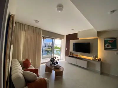 a living room with a couch and a tv at Exclusive oasis , Beach, pool and high comfort in Serena del Mar