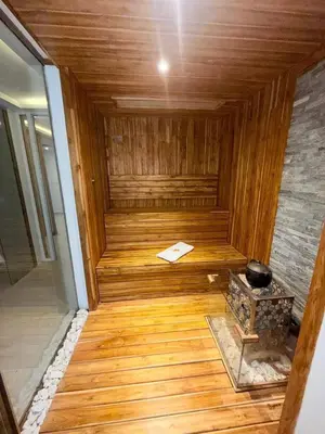 a wooden sauna with a wooden floor and a stove at Exclusive oasis , Beach, pool and high comfort in Serena del Mar