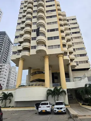 two cars parked in front of a large building at Apartment in El Cabrero in Cartagena de Indias