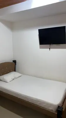 a bed in a room with a tv on the wall at GUILLOTE Comfort Loft in Cartagena de Indias