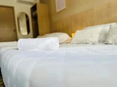 a bed with white sheets and pillows on it at Hotel Casa Obed in Cartagena de Indias