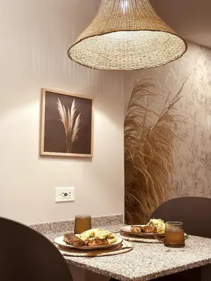 two plates of food sitting on a table under a light fixture at Apartamento Bohemio frente al Mar en Santa Marta in Santa Marta