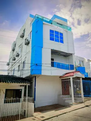 a blue and white building with a fence at Hospedaje Torices Cartagena in Cartagena de Indias