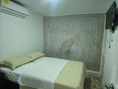a bedroom with a bed in a room with a wall at Hotel H&H in Cartagena de Indias