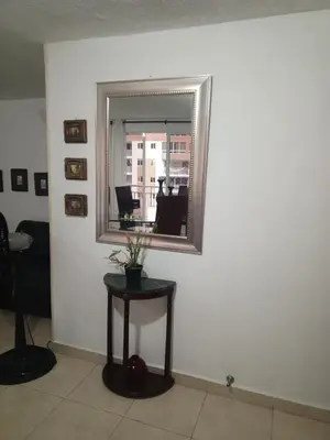 a mirror on a wall with a table in a room at Apartamento 3 alcobas barrio Miramar Barranquilla in Barranquilla
