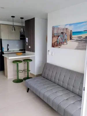 a living room with a couch and two green stools at Apartamento moderno cerca de la playa in Cartagena de Indias