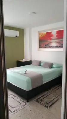 a bedroom with a bed with a painting on the wall at Oceanfront apartment in Cartagena de Indias