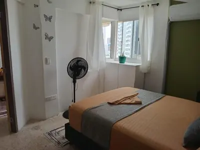 a bedroom with a bed and a window and a fan at Oceanfront apartment in Cartagena de Indias