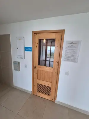 a wooden door in a white room with a window at Olas & relax Cartagena in Cartagena de Indias