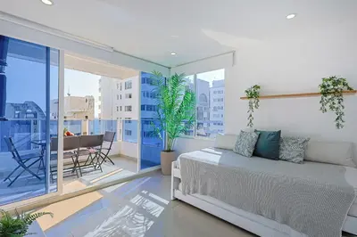 a bedroom with a bed and a balcony with a table at Riviera Suite - Apartamento con balcón in Cartagena de Indias