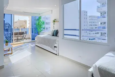 a bedroom with a bed and a large window at Riviera Suite - Apartamento con balcón in Cartagena de Indias