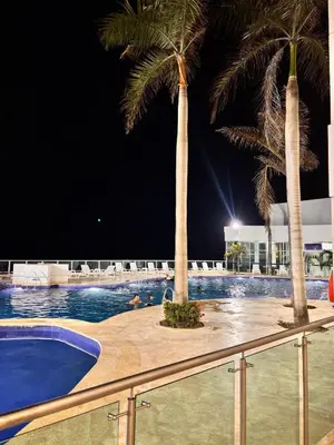 a swimming pool with two palm trees on a resort at Apartment in Cartagena 5 minutes from the historic center in Cartagena de Indias