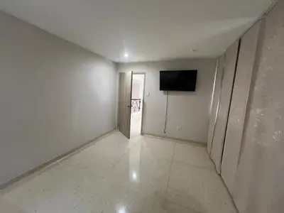 a hallway with a television and a white wall at Casa Mansion in Barranquilla