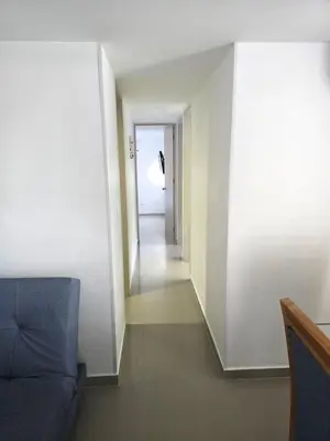 a living room with a couch and a hallway at Acogedor apto en Coveñas 204 in Coveñas