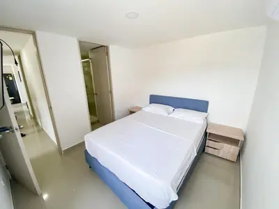 a bedroom with a large bed with a blue headboard at Acogedor apto en Coveñas 204 in Coveñas