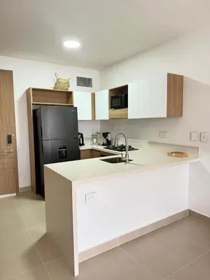 a kitchen with white cabinets and a black refrigerator at 2BR 2BA Apt Baia Kristal Cartagena Crystal Lagoon in Cartagena de Indias