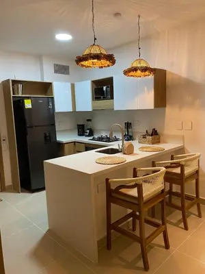 a kitchen with a island with chairs and a counter top at Vista a la laguna - Baia Kristal in Los Arrayanes