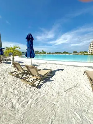 a group of chairs and an umbrella on a beach at Vista a la laguna - Baia Kristal in Los Arrayanes