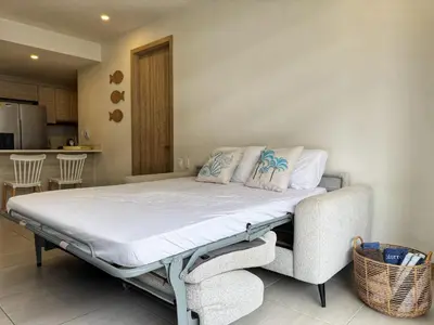 a large bed in a room with a kitchen at Shoreline Escape - Private Pool - Beach in Cartagena de Indias