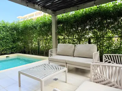 a patio with a couch and chairs next to a swimming pool at Shoreline Escape - Private Pool - Beach in Cartagena de Indias