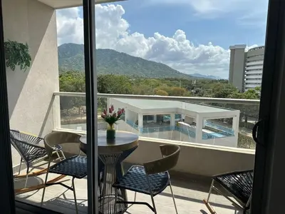 a balcony with a table and chairs and a view at New luxury studio apartment with ocean view, Santa Marta in Simón Bolivar