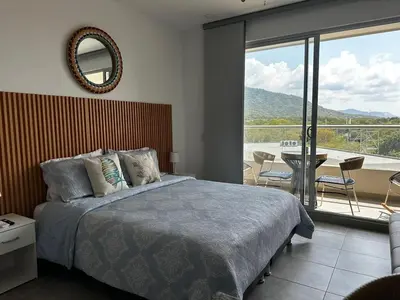 a bedroom with a bed and a balcony with a view at New luxury studio apartment with ocean view, Santa Marta in Simón Bolivar