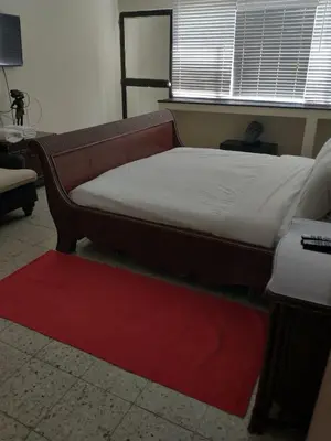 a bed sitting in a room with a red rug at Casa - EL LAGUITO in Cartagena de Indias