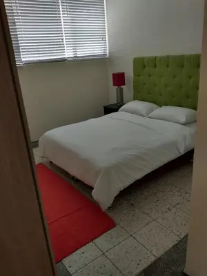 a bedroom with a large bed and a red rug at Casa - EL LAGUITO in Cartagena de Indias
