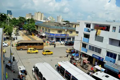 a busy city street with buses and cars and buildings at Hotel San Marcos Barranquilla in Barranquilla