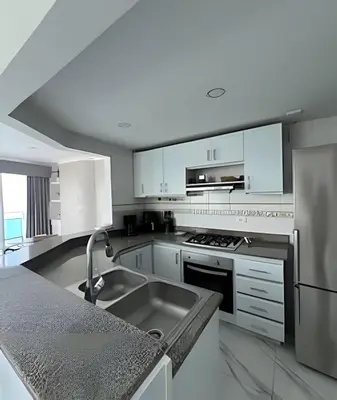 a kitchen with white cabinets and a stainless steel sink at Alojamiento exclusivo frente al mar in Santa Marta