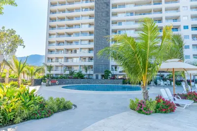 a hotel with a palm tree and a swimming pool at Apartamentos Exclusivos Santa Marina - AR Rentals in Santa Marta