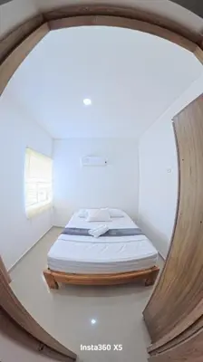 a bed in a room with a round mirror at Amanecer Caribe 4503 in Coveñas