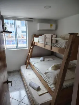 two bunk beds in a room with a window at Teca, Apto , Caribe in Coveñas