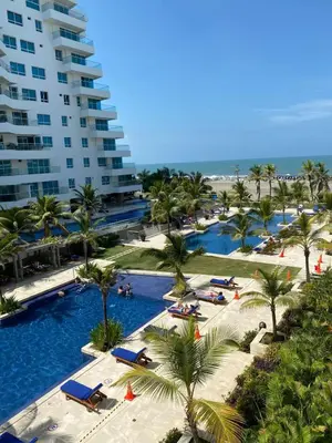 a resort swimming pool with palm trees and a building at NOK Oceanside getaway in Cartagena in Cartagena de Indias