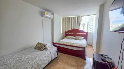 a small bedroom with two beds and a window at Apt 3 rooms Laguito Cartagena 1 block from the beach in Cartagena de Indias