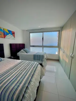 a bedroom with two beds and a large window at Apartamento de 2 Habitaciones Vista al Mar in Cartagena de Indias