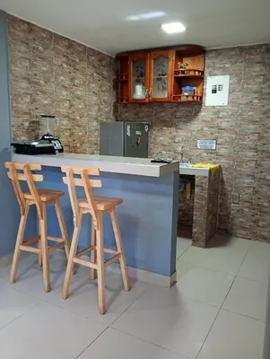 a kitchen with two stools at a blue counter at Posada mary in Cartagena de Indias