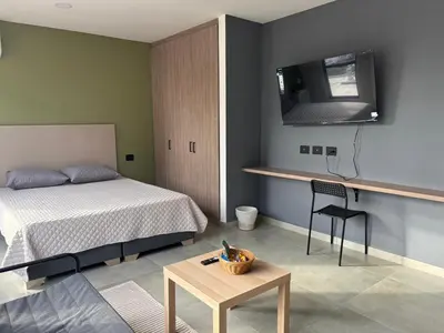 a bedroom with a bed and a tv on the wall at Suite Coral Tower in Barranquilla