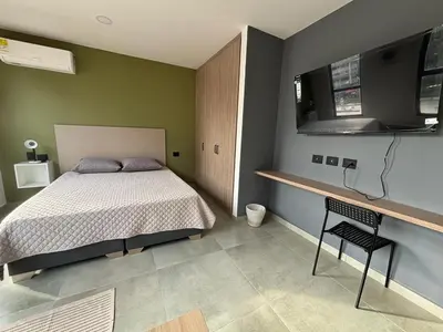 a bedroom with a bed and a desk with a chair at Suite Coral Tower in Barranquilla