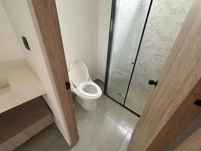 a bathroom with a toilet and a glass shower at Suite Coral Tower in Barranquilla
