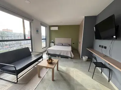a room with a bed and a couch and a tv at Suite Coral Tower in Barranquilla