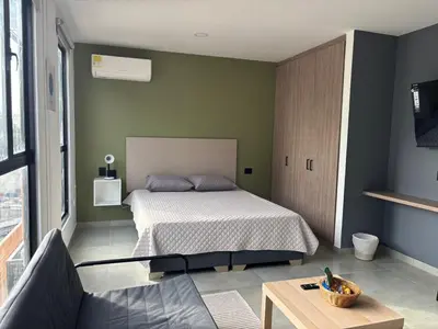a bedroom with a bed and a couch and a table at Suite Coral Tower in Barranquilla