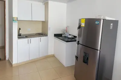 a kitchen with a stainless steel refrigerator and white cabinets at Azul Caribe Home in Cartagena de Indias