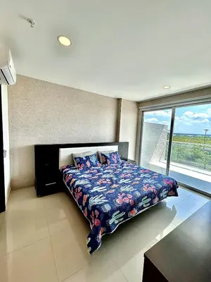 a bedroom with a bed and a large window at Apartamento con piscina gigante y acceso directo al mar in Cartagena de Indias